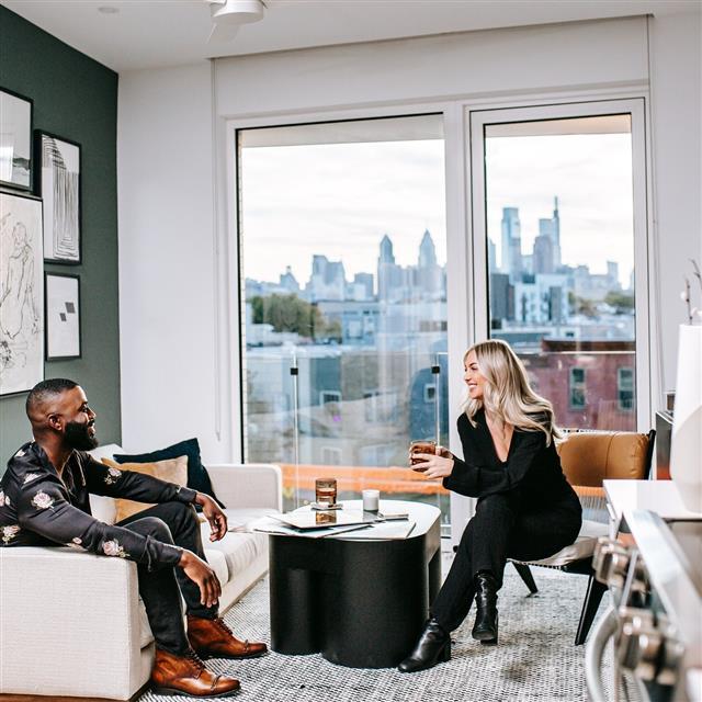 A man and a woman chat with a view of the city.