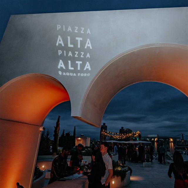 People outdoors at night at the Aqua Foro